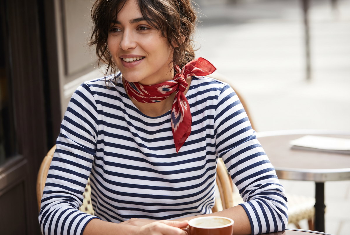 Woman in a breton stripe tee wearing a scarlet ikat neckerchief